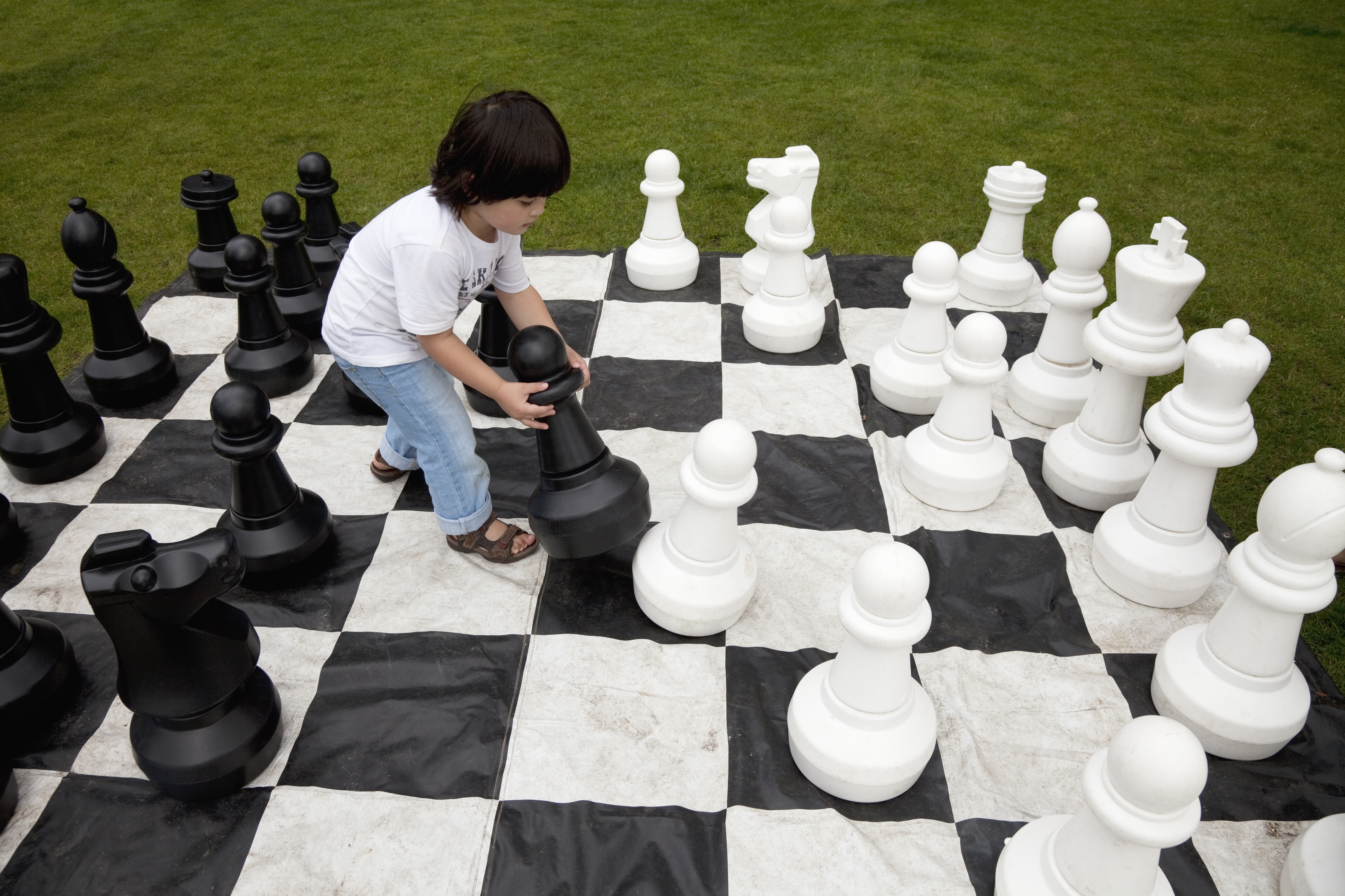 a kid lifting the heavy chess pieces