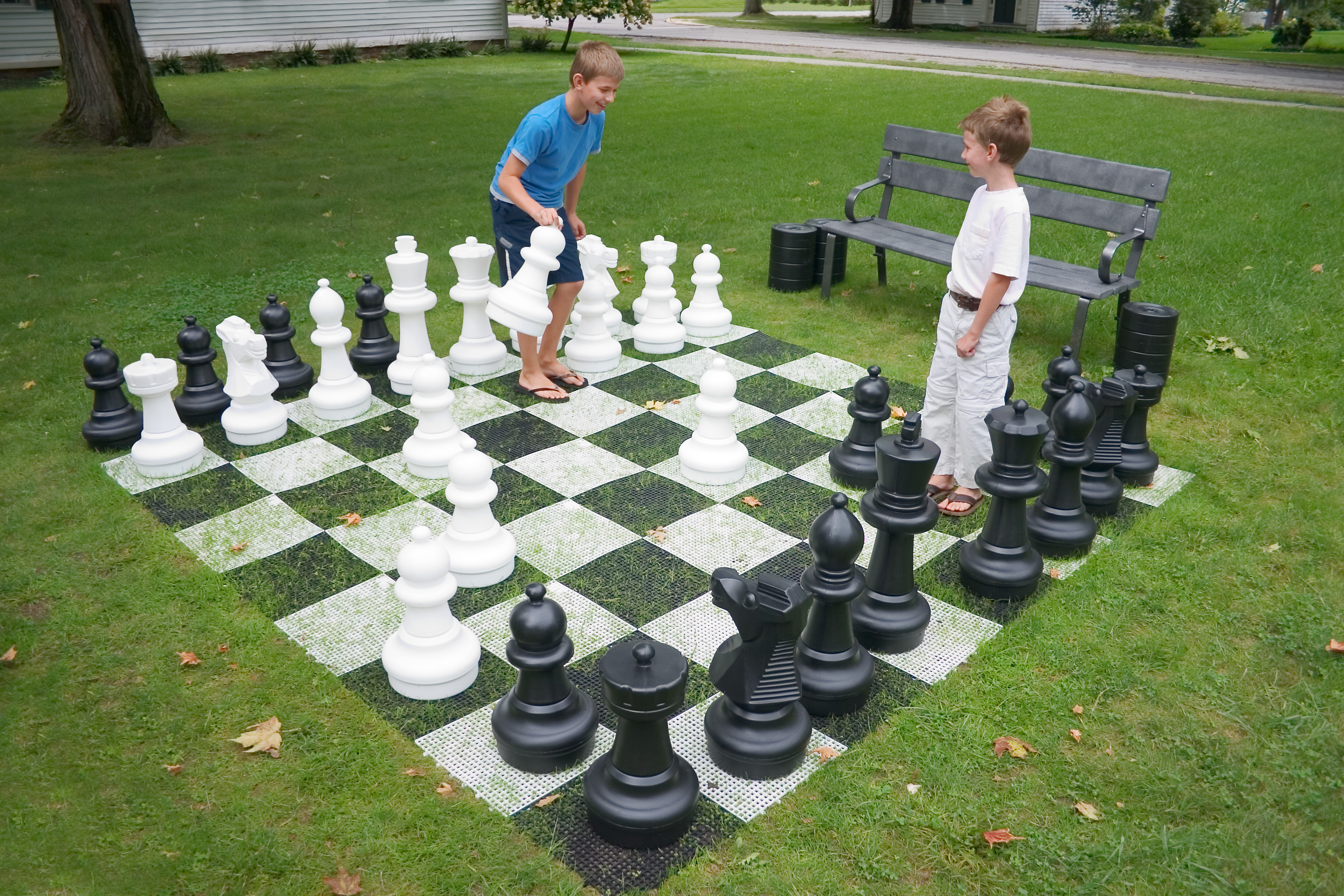 kids playing chess on the ground outside