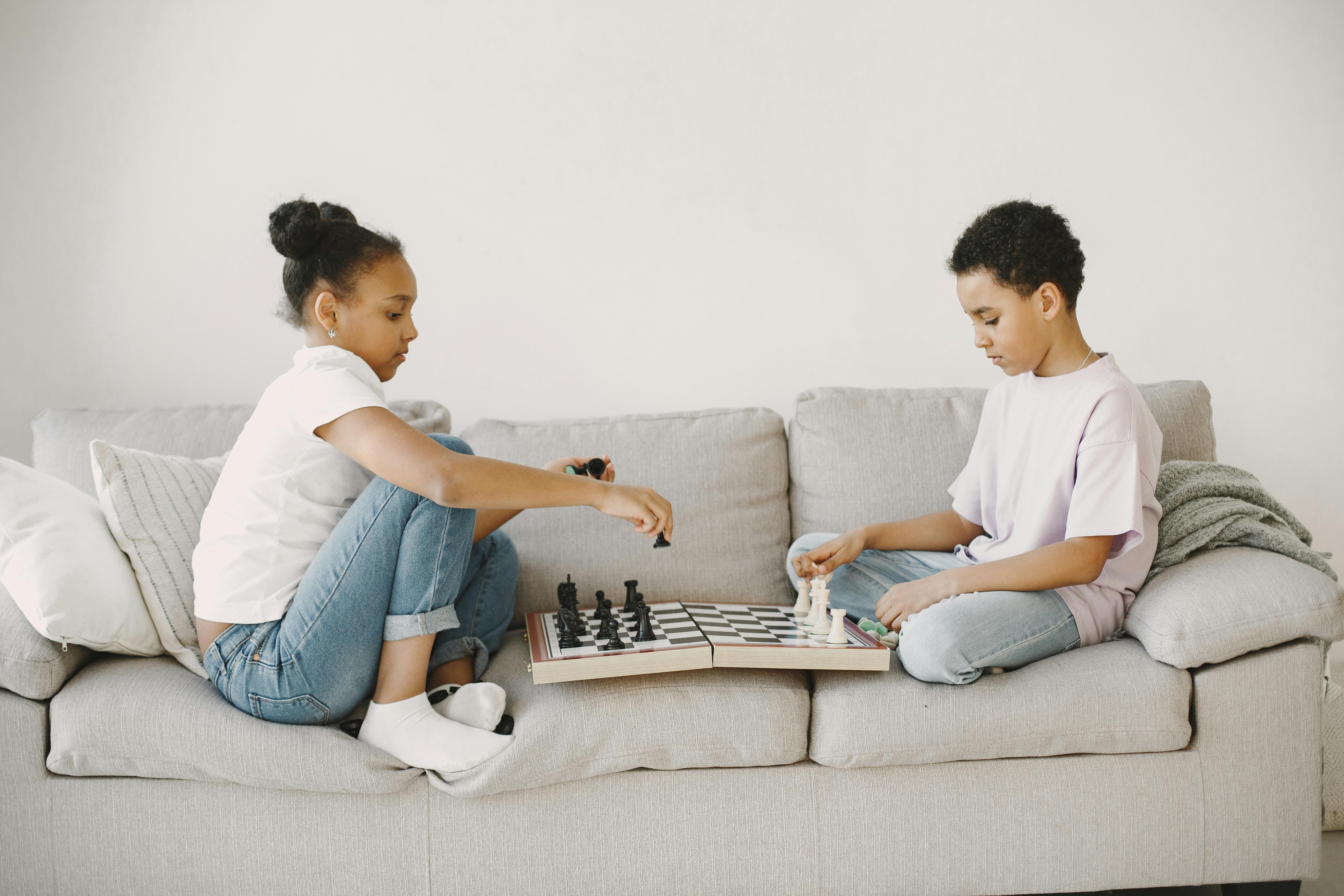 siblings practicing chess at home